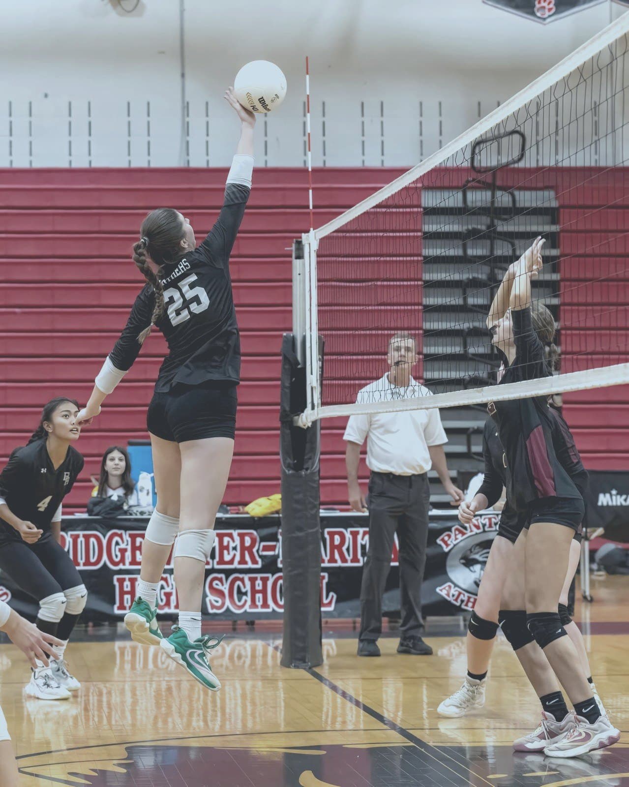 Athlete drives a spike over the net