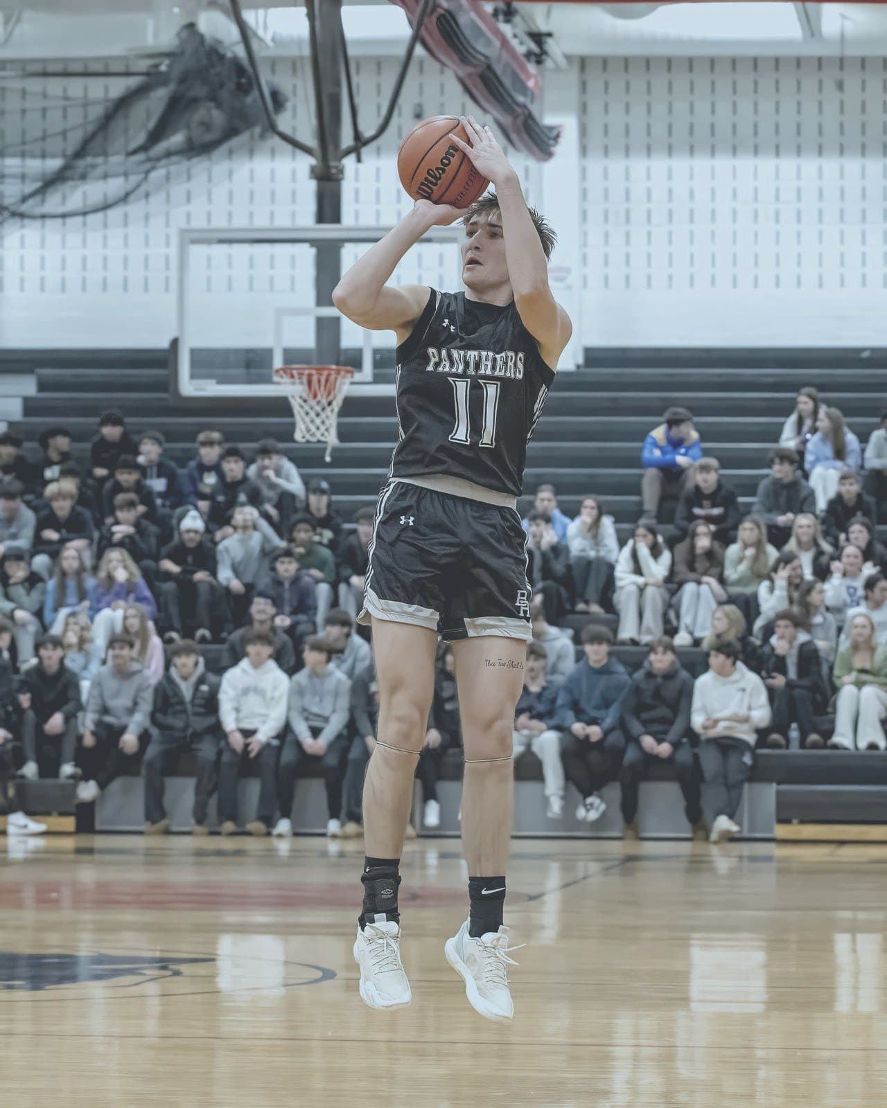 Athlete rises for a jump shot in a packed gymnasium