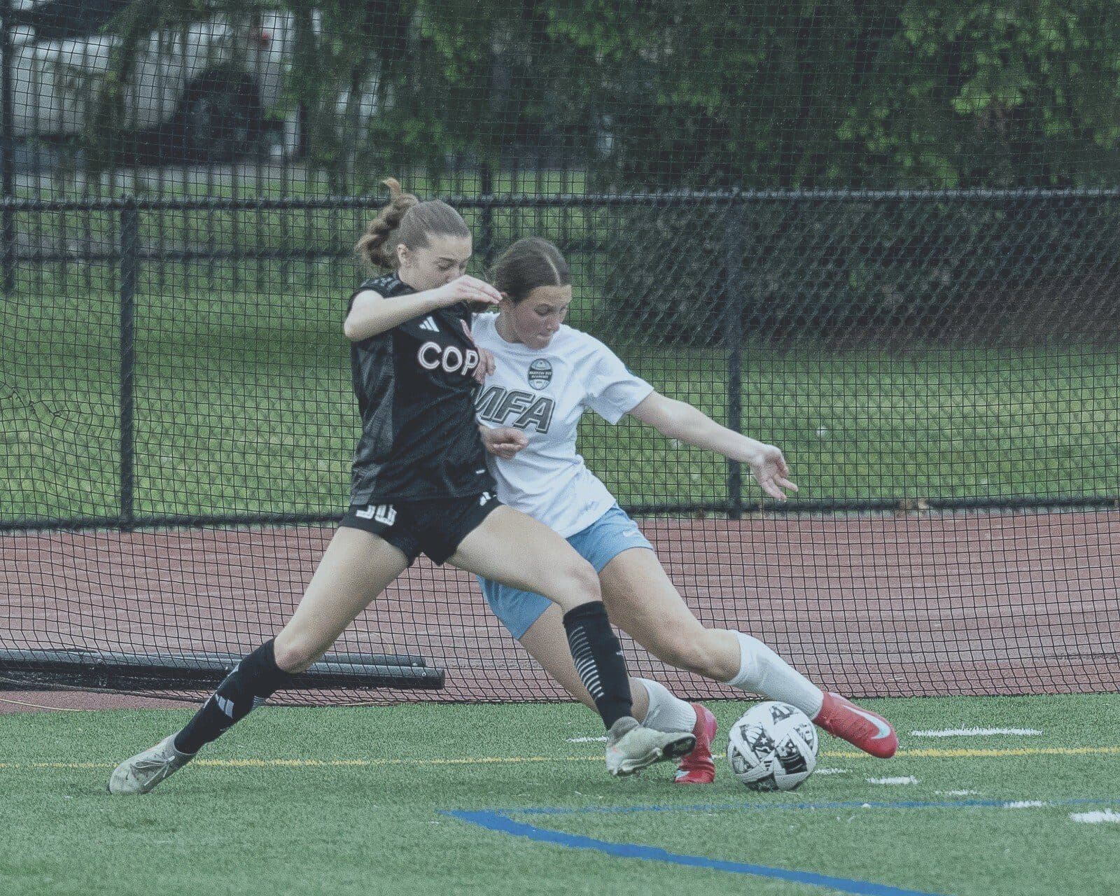 Two players battle for the ball in an aerial challenge