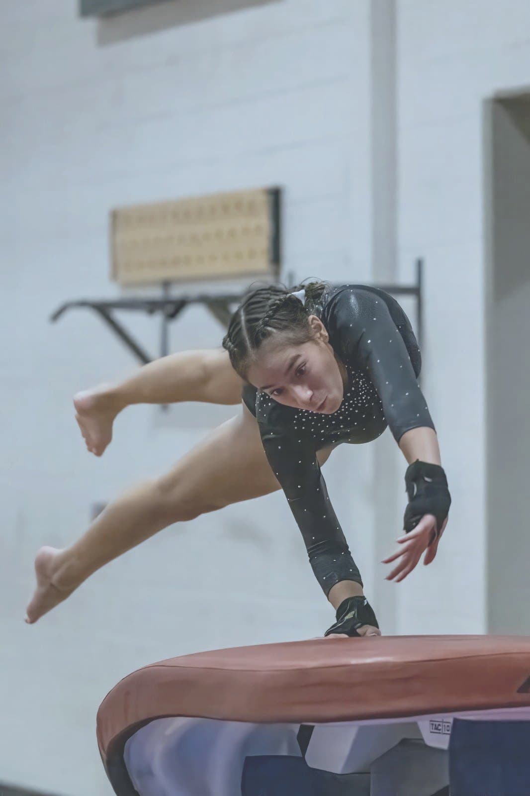 Gymnast launches off the vault with intensity